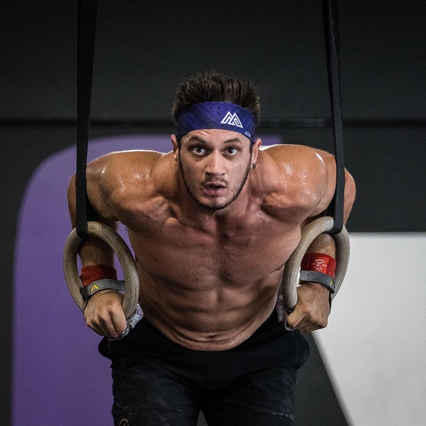 Travis Williams performing CrossFit ring dips, looking ripped and fit
