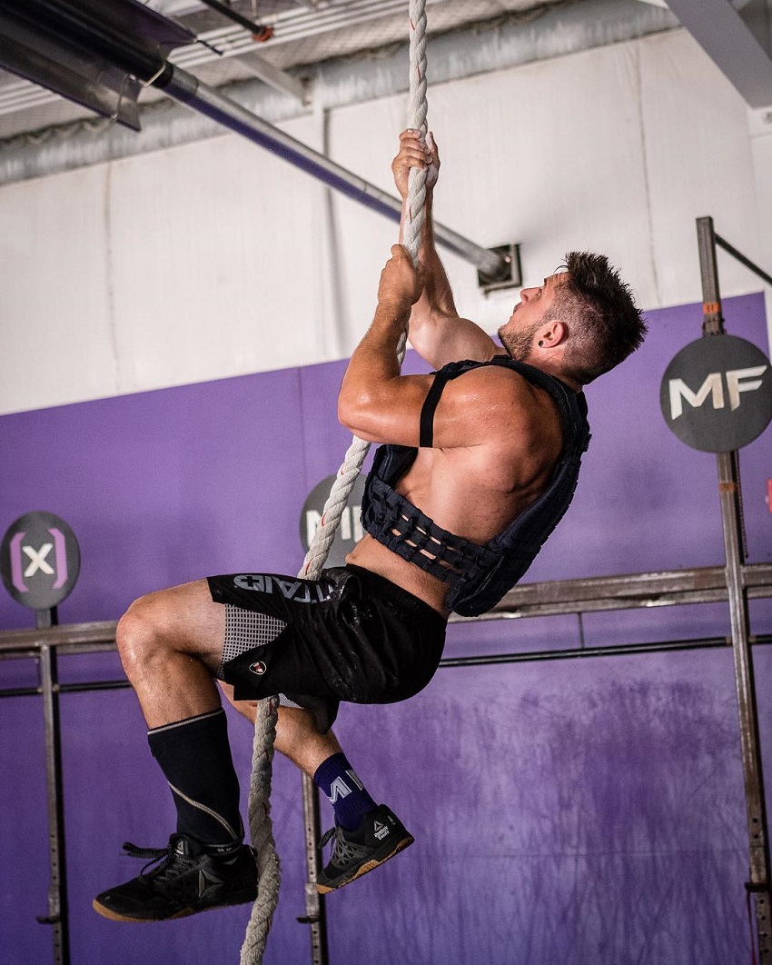 Travis Williams climbing a rope during CrossFit training