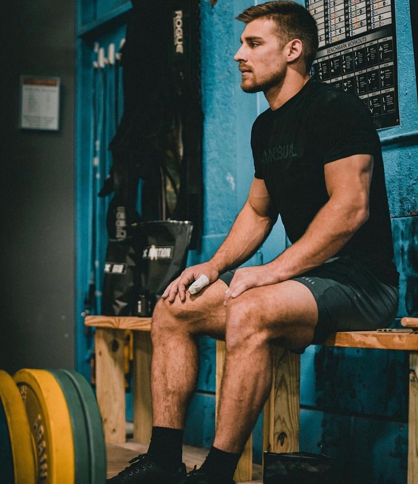 Alex Anderson sitting on a wooden chair looking strong and fit