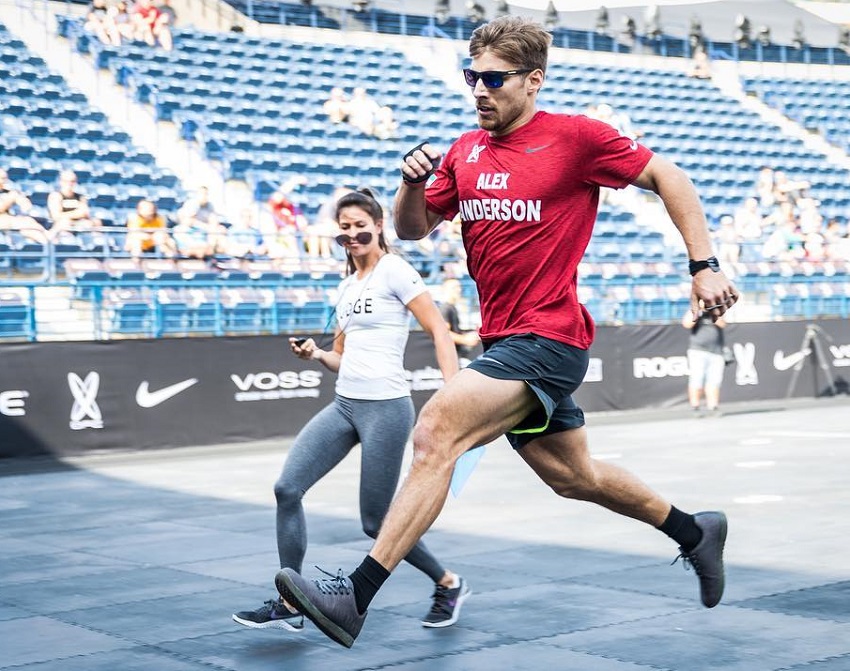 Alex Anderson running on a track with a female by him