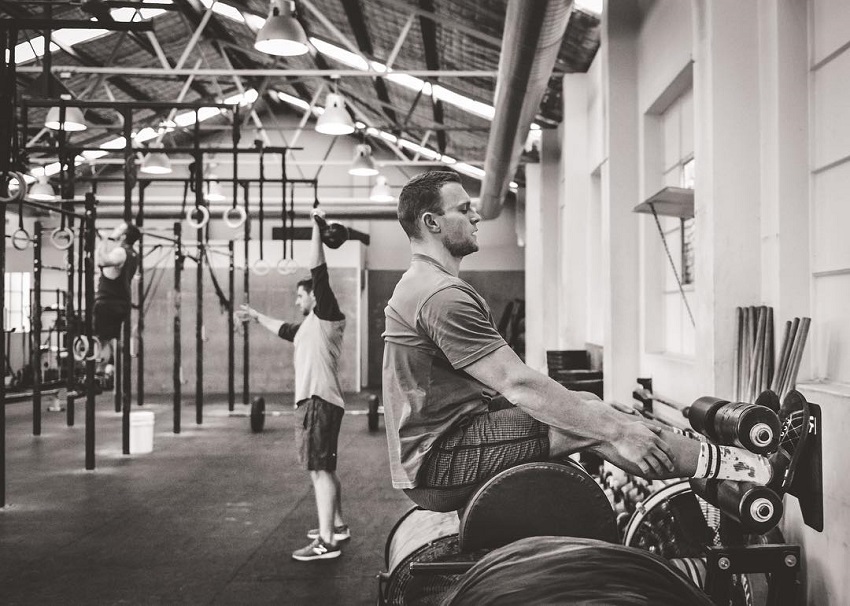 Chad Mackay sitting in a CrossFit gym preparing to do heavy weightlifting