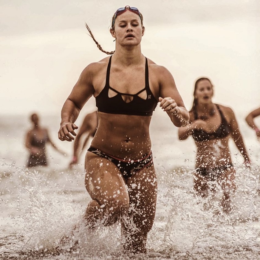 Dani Elle Speegle running in shallow water competing against other athletes