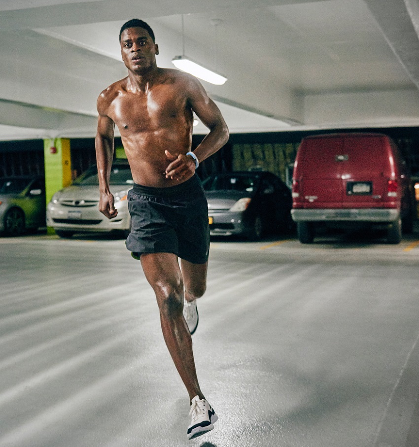 Joe Holder running shirtless in an underground parking lot