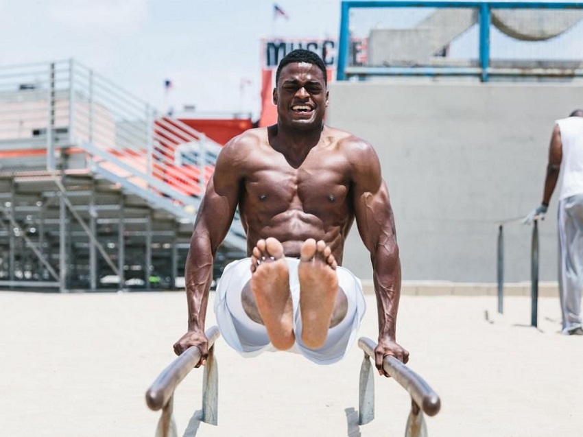 Joe Holder doing an exercise on bars on the beach