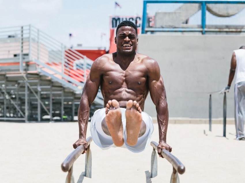 Joe Holder doing an exercise on bars on the beach