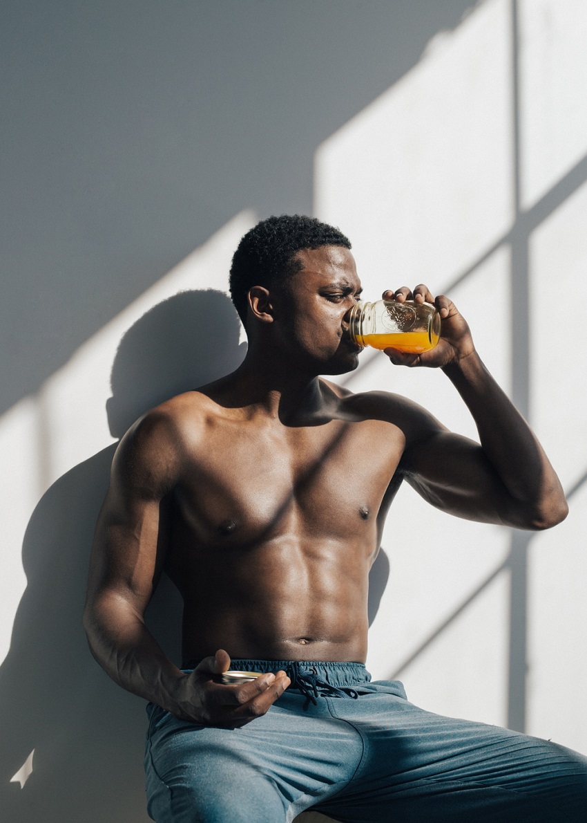 Joe Holder drinking a healthy juice while being shirtless