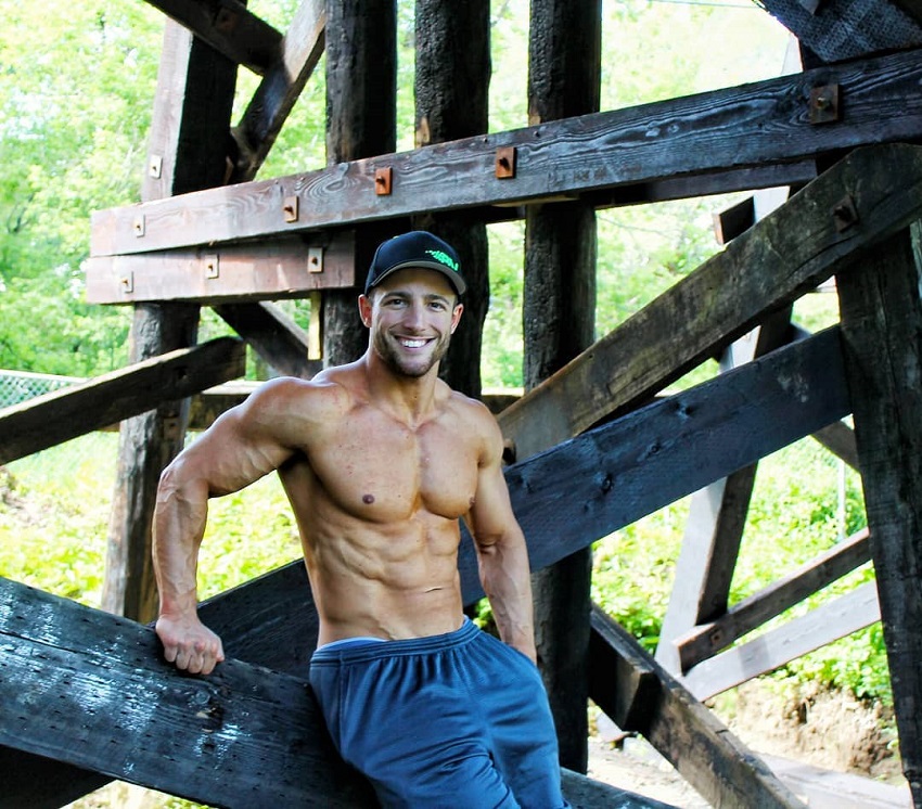 Jonathan Plante leaning against a construction, posing shirtless outdoors