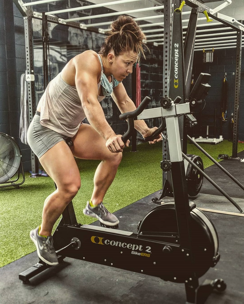 Kara Webb Saunders doing cardio on a stationary bicycle