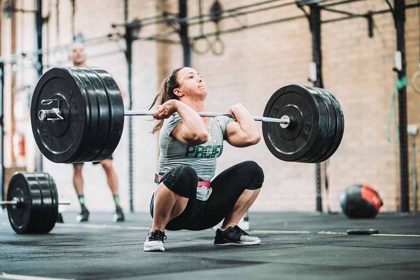 Kara Webb Saunders lifting a barbell loaded with weights during CrossFit training