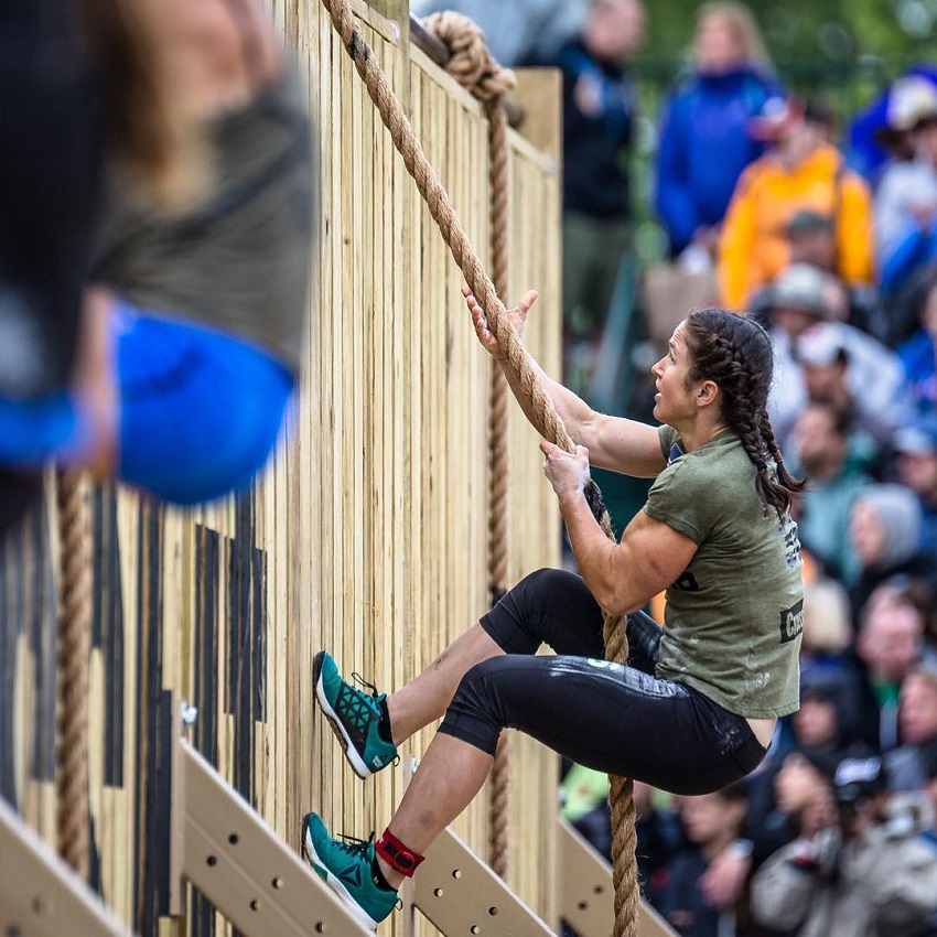 Kari Pearce climbing a rope during a CrossFit event