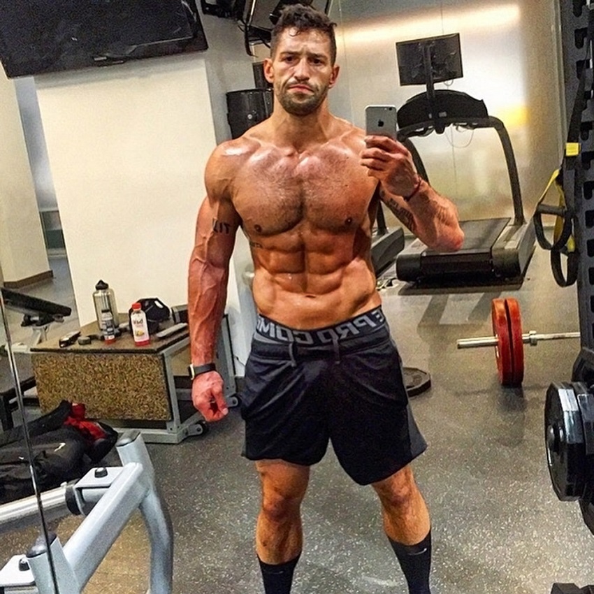 Noah Neiman taking a selfie of his shirtless physique, looking strong and lean