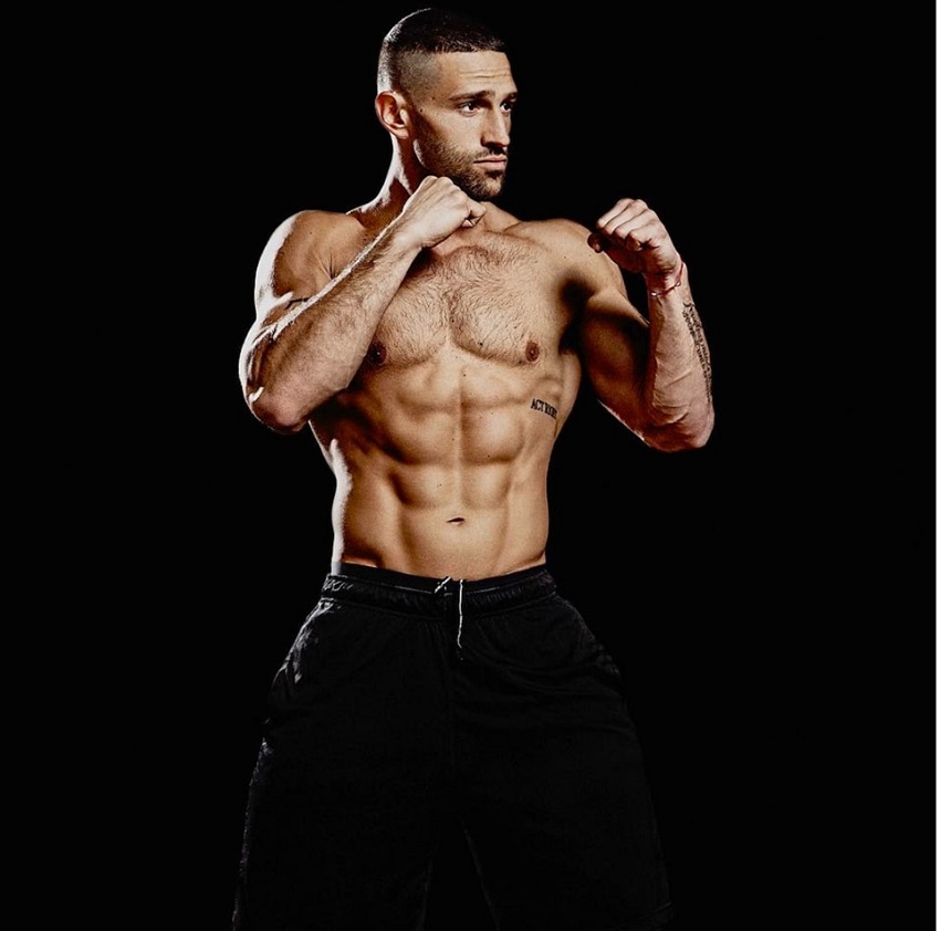 Noah Neiman posing shirtless in a boxing stance looking fit and lean