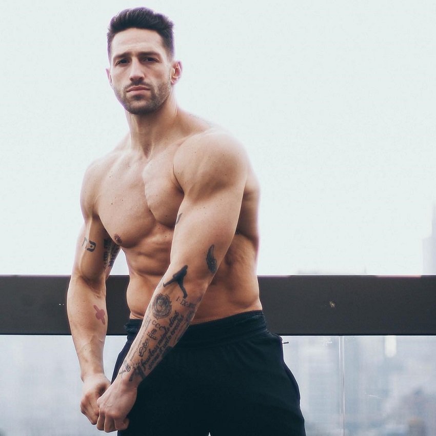 Noah Neiman posing shirtless for a photo looking muscular and strong