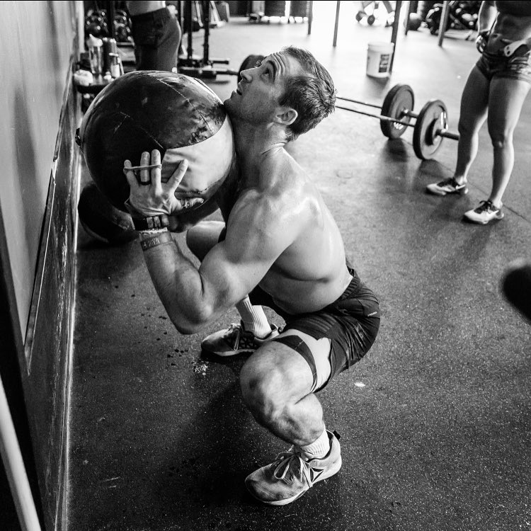 Ben Smith lifting heavy medicine ball during CrossFit training