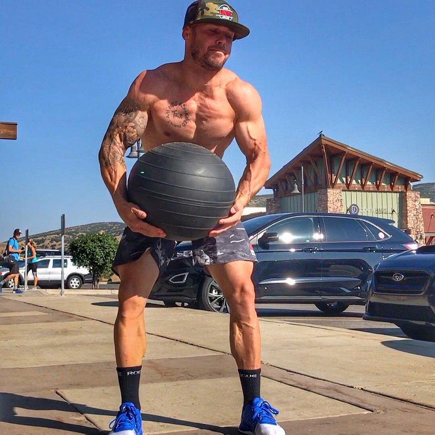Chris Spealler lifting a heavy medicine ball in the oudoors parking lot