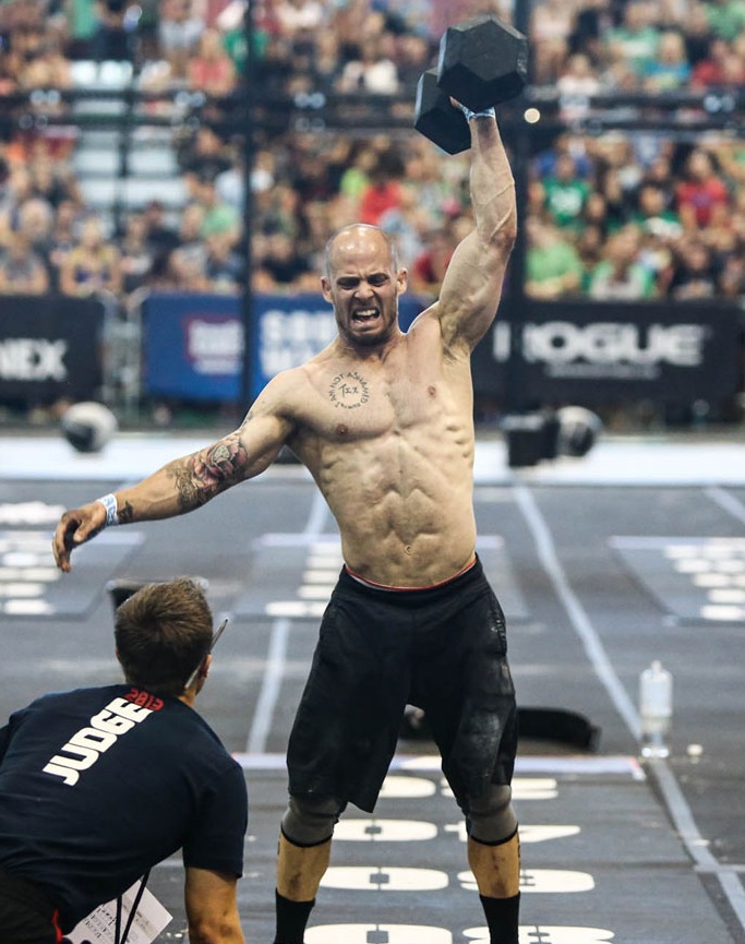 Chris Spealler lifting a dummbbell over his head during a CrossFit competition