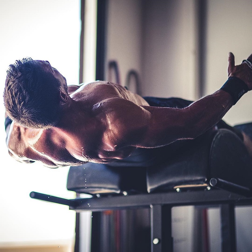 Dan Bailey exercising shirtless on a bench