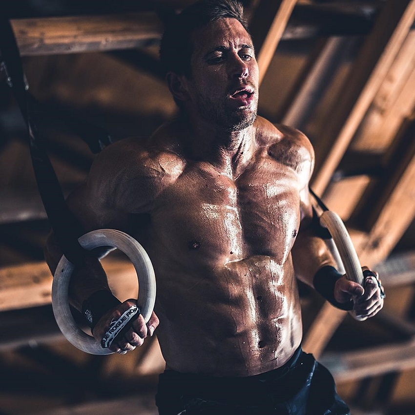 Dan Bailey performing ring exercises while being shirtless