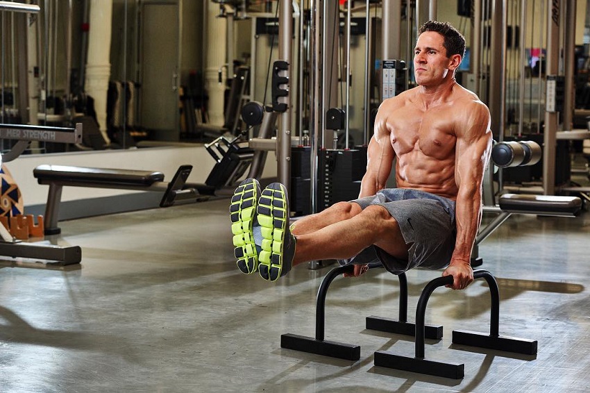 Don Saladino doing triceps dips with his legs raised up, working on his abs and triceps