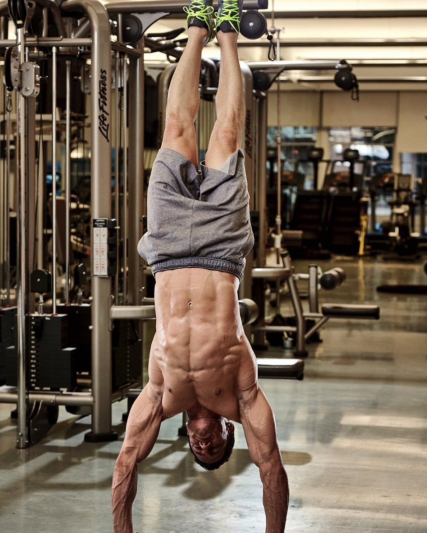 Don Saladino doing a shirtless handstand looking fit and riped