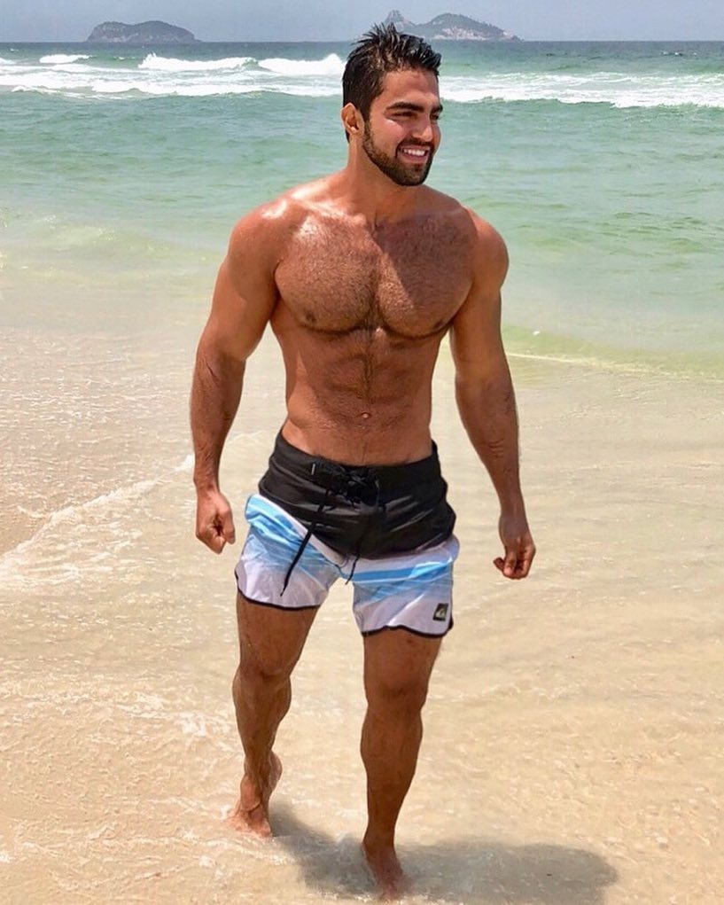 Jefferson Ferreira standing shirtless on the beach looking ripped