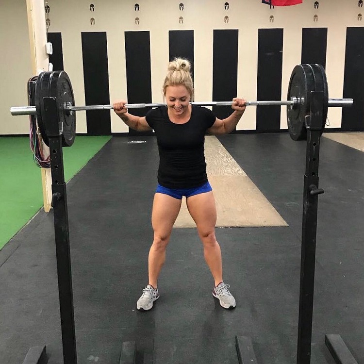 Kylee Nicole doing heavy squats with a barbell looking happy and fit