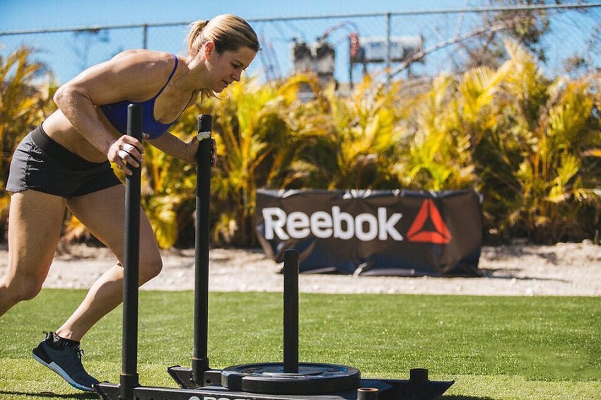 Rebecca Voigt Miller pushing a weighted cart during a CrossFit competition