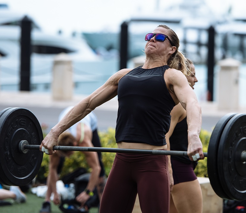 Rebecca Voigt Miller doing heavy barbell lifts during a CrossFit event