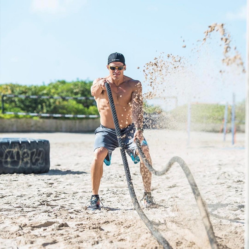 Shawn Ramirez performing battle ropes on the beach