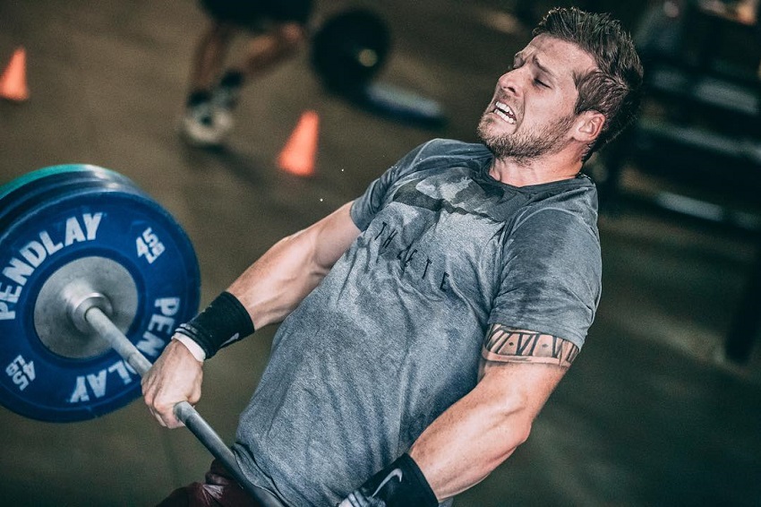 Travis Mayer lifting a heavy barbell looking fit and strong