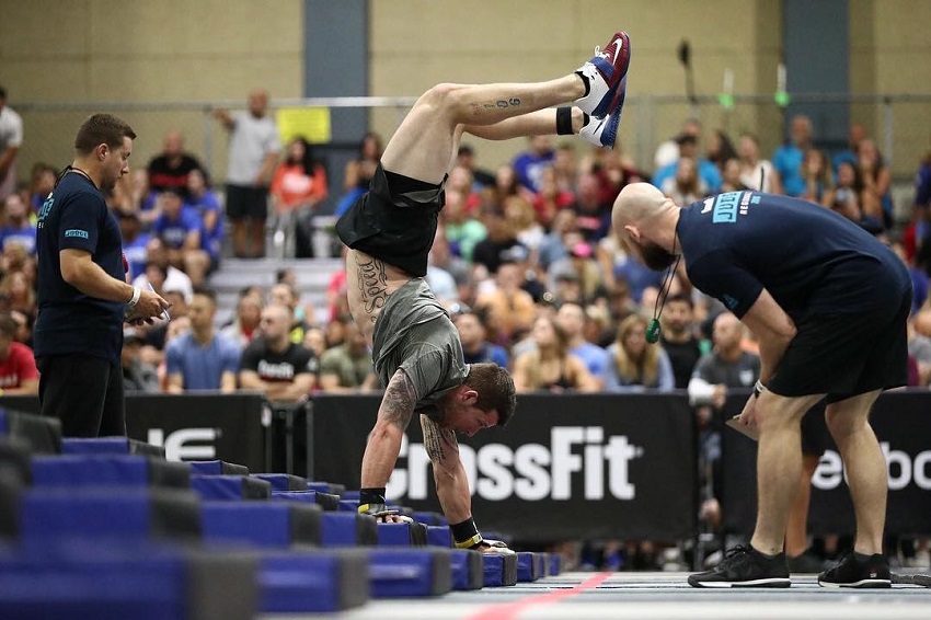 Travis Mayer performing a handstand looking strong and fit