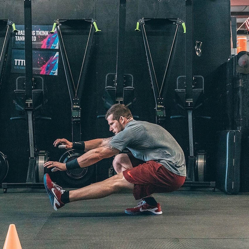 Travis Mayer doing single-leg squats in a CrossFit gym