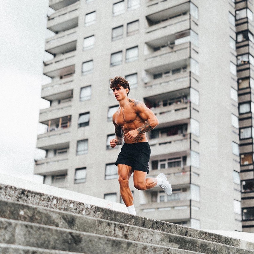 Adi Gillespie running shirtless on top of a building