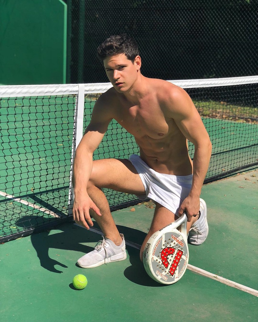 Andrea Moscon posing by a tennis court looking ripped