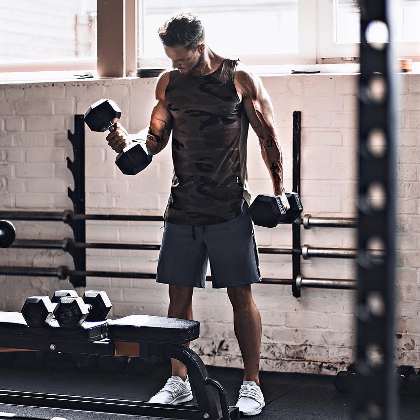 Daniel Fox doing biceps curls in the gym looking strong