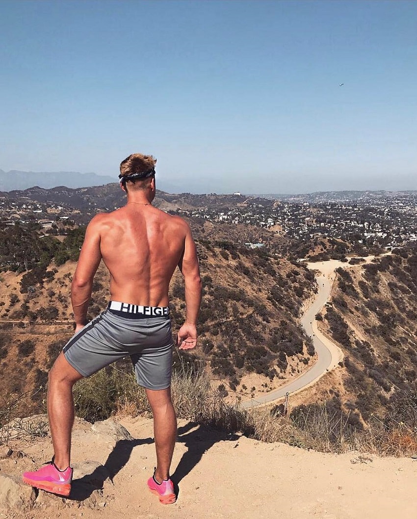 Max Wyatt standing shirtless on a hill looking strong and fit