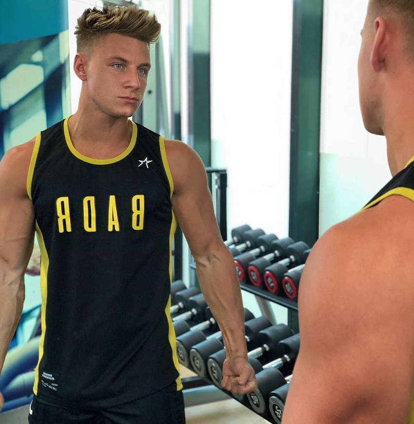 Max Wyatt looking at himself in the mirror in the gym.