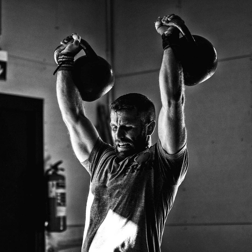 Mikko Salo doing an overhead press with kettlebells