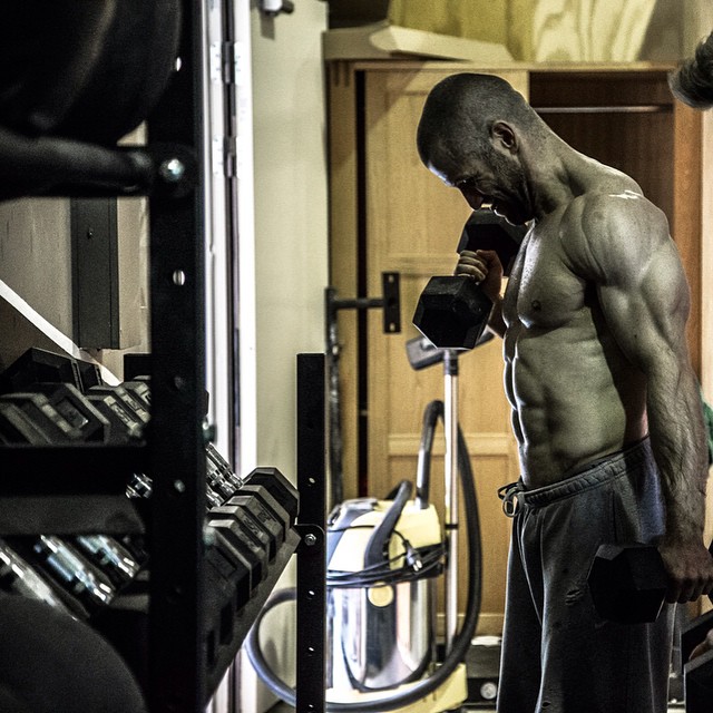 Mikko Salo lifting heavy dumbbells in a gym looking fit and strong