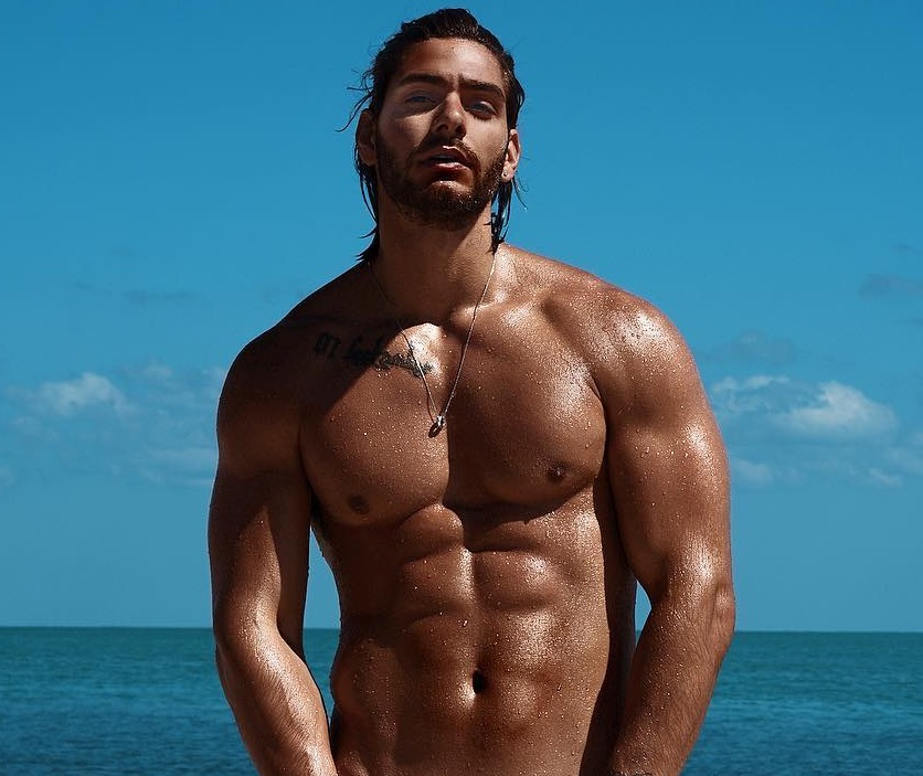 Paul Iskandar posing shirtless by the sea looking ripped