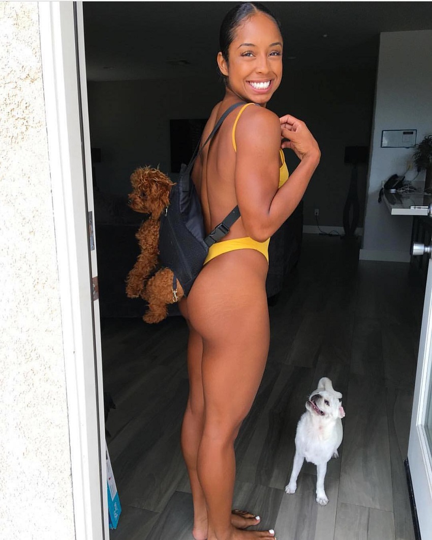 Qimmah Russo posing for a picture with her dog looking fit and curvy