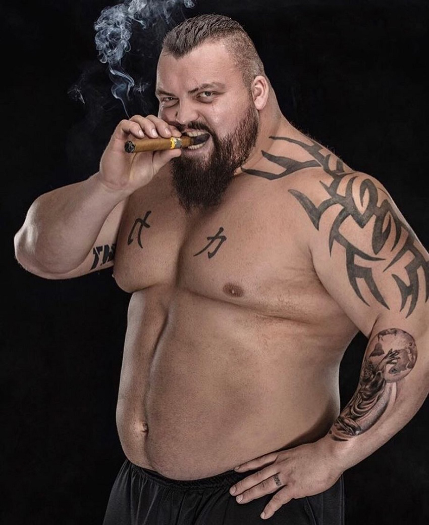 Eddie Hall smoking a cigarette shirtless