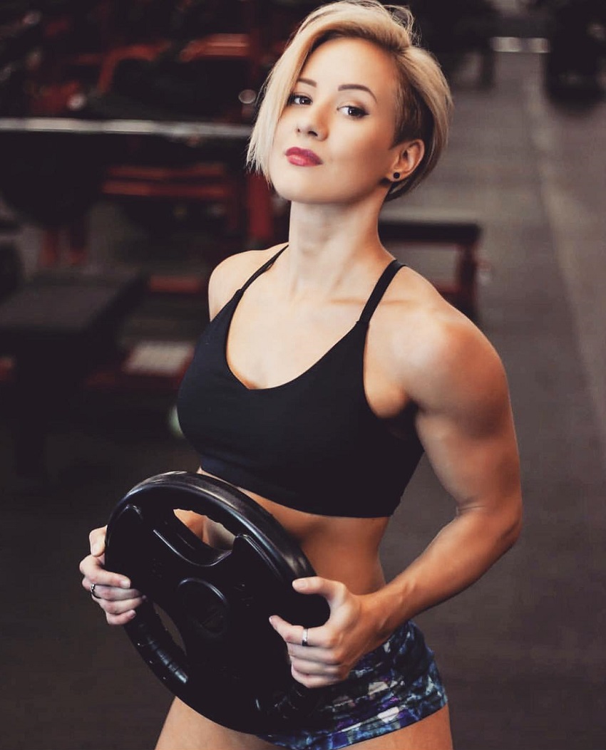 Elena Soboleva posing in a photo shoot with a weight plate in her hands