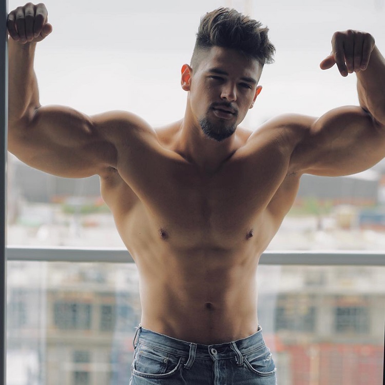 Jamar Pusch flexing his muscles on a balcony