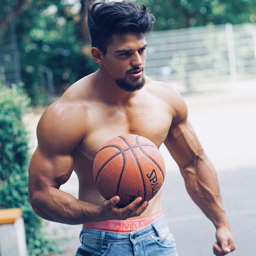 Jamar Pusch holding a basketball in his hands while standing shirtless