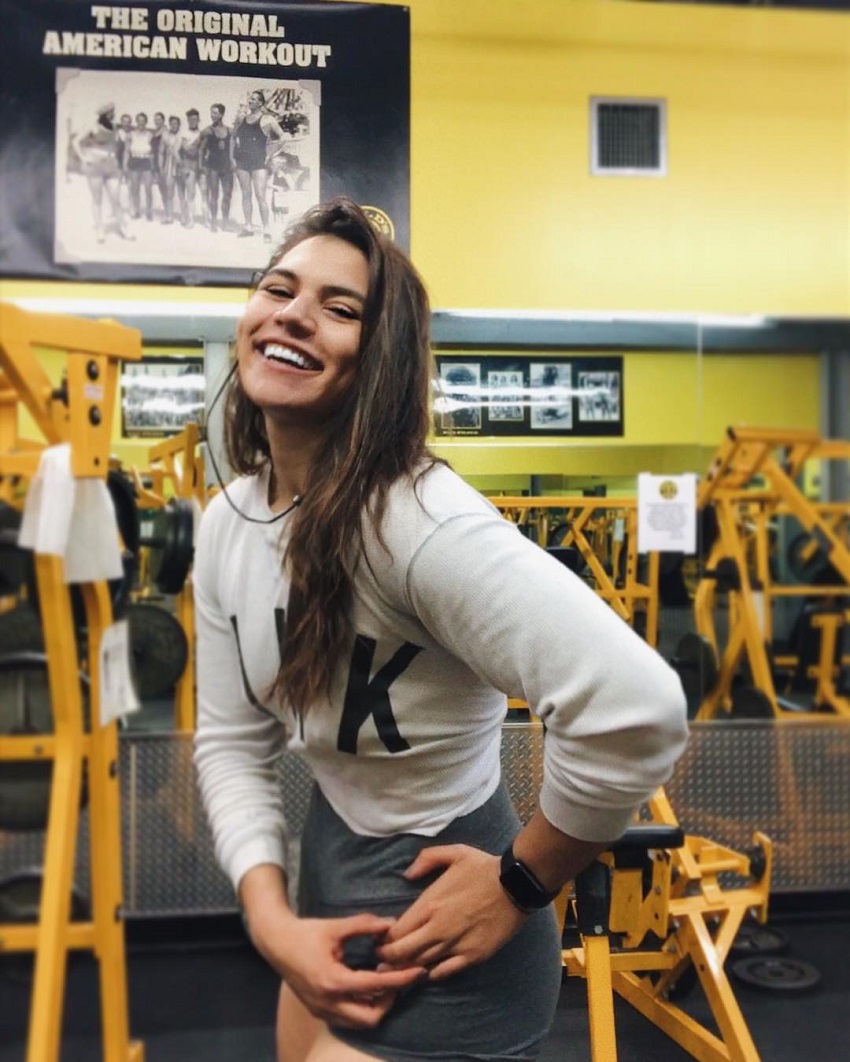 Laura Micetich smiling for a photo in the gym
