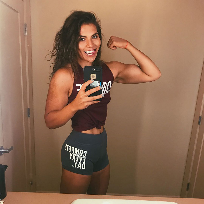 Laura Micetich flexing her biceps for the photo looking lean and strong