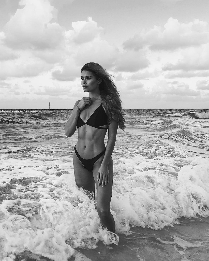 Pamela Reif standing in the ocean looking fit and lean