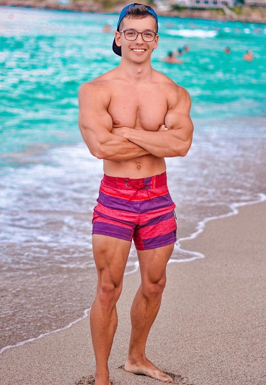 Radoslav Raychev standing shirtless on the beach looking strong and ripped