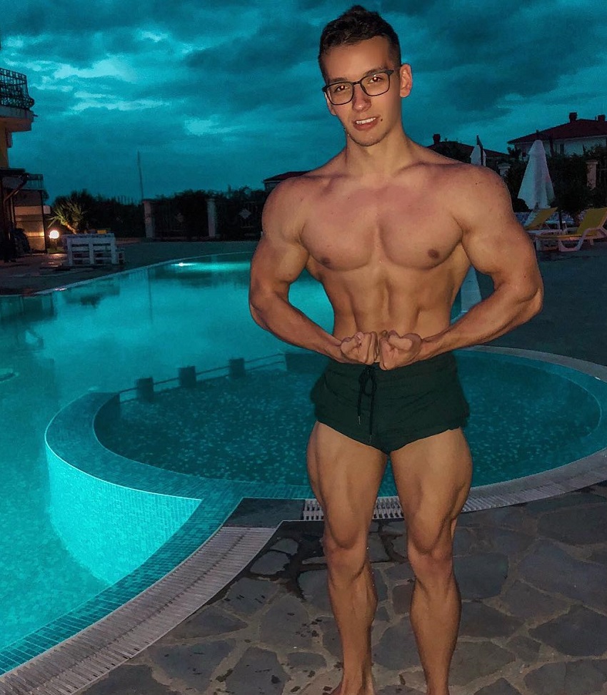 Radoslav Raychev flexing his muscles for a picture standing in front of a pool